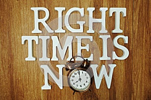 Right Time Time is Now alphabet letter with alarm clock on wooden background