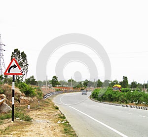 Right turn sign board on a highway at a right curve on road