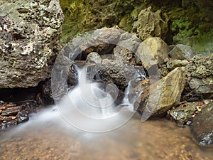 Rill from cave in forest photo