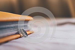 Ring and a book on the bed