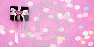 Ring box with ribbon on bokeh background. Baner