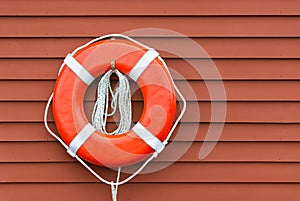 Ring buoy on red wooden wall