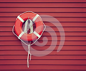Ring buoy on red wooden wall