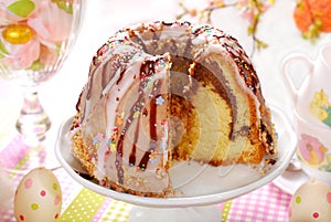 Ring cake with icing and chocolate glaze on easter table