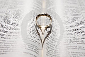 Ring casting heart shadow on bible