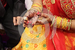 Ring ceremony and the wedding function of the Hindu Indian couple holding gold ring with diamond.