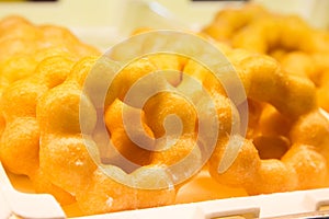 Ring doughnut fresh from the bakery with sprinkle sweets and icing on top