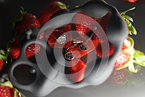 Ring and earrings with the symbol of bdsm lying among the strawberries next to the sex toy caterpillar