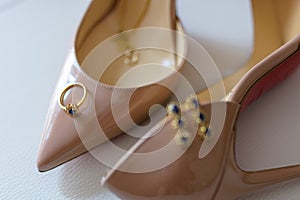 Ring and earrings on top of high heel shoes