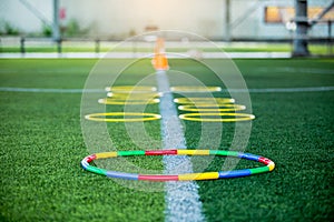 Ring ladder marker are soccer training equipment on green artificial turf with blurry cone marker