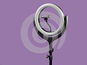 ring lamp with the smartphone holder on lilaceous background photo