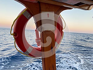 Ring life boy on big boat.Obligatory ship equipment.Personal flotation device.Prevent drowning.Orange lifesaver on the deck of a