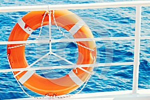 Ring life buoy on boat. Obligatory ship equipment. Orange lifesaver on the deck of a cruise ship