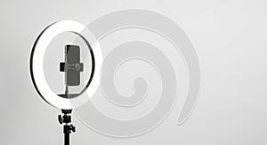 Ring light with smartphone holder for content creation and photography setup isolated on white background