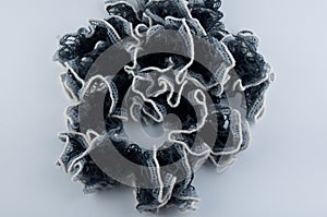 Ring made of black and white scarf laying on white background
