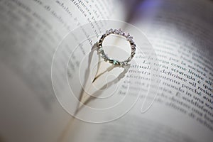 Ring between the pages of a book that projects a shadow in the shape of a heart