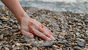 Ring on the sea, on his hand put on, a beautiful girl`s hand overlooking the sea on the beach stony
