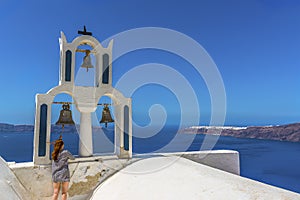 Ringing the bells of a  tower on a church on Skaros Rock in Santorini