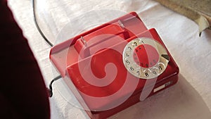 Ringing a red Rotary dial telephone