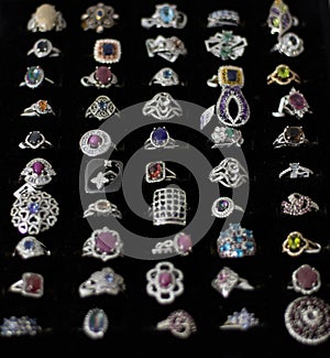 Rings with different precious stones, materials, sizes and shapes in the display of a jewelry