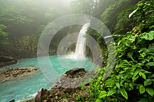 Rio celeste waterfall at foggy day photo