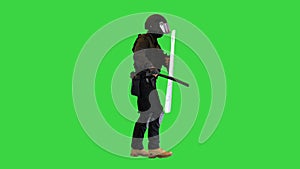 Riot policeman hitting shield with the baton while walking on a Green Screen, Chroma Key.