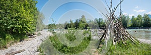 Riparian zone Isar river with wooden tent and gravel banks, panorama landscape bavaria