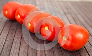 Ripe appetizing san marzano tomatoes on wooden table