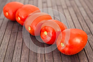 Ripe appetizing san marzano tomatoes on wooden table
