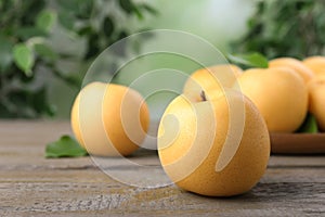 Ripe apple pears on wooden table against blurred background. Space for text