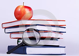 Ripe apple on stack of books