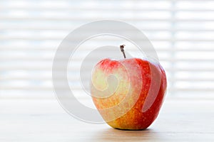 Ripe apple on the table in morning light. Diet breakfast, healthy food