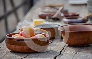 Ripe apples in a ceramic bowl close-up, pottery on a wooden table, medieval lifestyle, still life