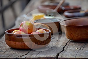 Ripe apples in a ceramic bowl close-up, pottery on a wooden table, medieval lifestyle, still life