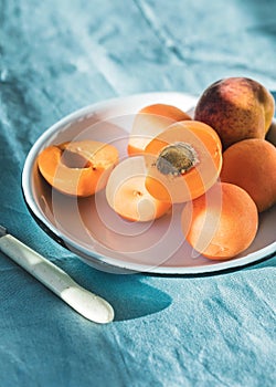 Ripe apricots and apricot leaves in a bowl on a wooden table. Fresh fruits from the home garden. Healthy food