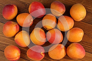 Ripe apricots on a brown wooden table. Top-down view. Closeup