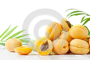 Ripe apricots in droplets of water on a white wooden table.