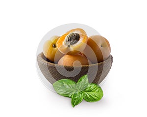 Ripe apricots isolate on a white. Bowl with apricots with leaves isolated on white background. Ripe apricots with copy space for t