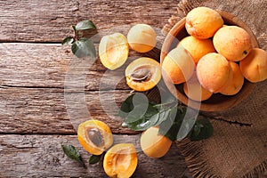 Ripe apricots in a wooden bowl on the table closeup. horizontal