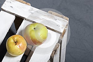 Ripe aromatic apples. Located on a wooden box, knocked out of the boards.