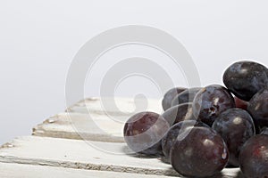 Ripe aromatic plums. Located on a wooden box, knocked out of the boards.