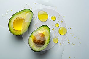Ripe avocado cut in half with drops of avocado oil on a white background. Healthy organic food, super food, oil for cooking,