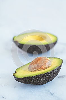 Ripe avocado cut in half on white background