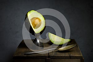 Ripe Avocado cut open with a spoon still life