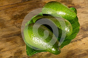 Ripe avocado on a green plate standing on a wooden table