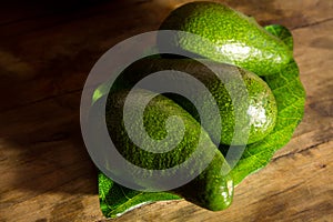 Ripe avocado on a green plate standing on a wooden table