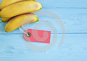 Ripe bananas on a blue wooden background tag