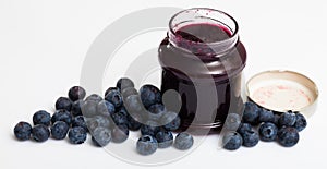 Ripe bilberries and jar of blueberry jam
