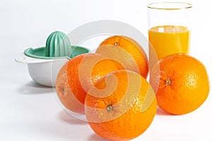 Ripe bio oranges and a glass of fresh squeezed orange juice on white wooden background. Organic Sicilian oranges