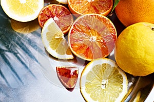 Ripe bio sliced oranges and lemons on steel tray top view. Organic Sicilian oranges. Healthy eating concept. Vitamin C